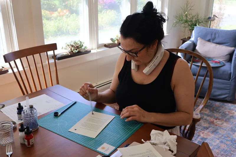 Saffron Samuels adding ink details to participant welcome letters