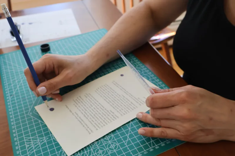 Hand-finishing a welcome letter with ink and pencil