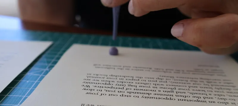 Close-up of an ink drop being placed on a welcome letter