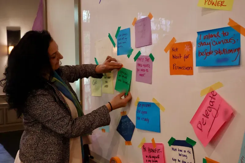 Saffron Samuels placing participant intentions on the wall