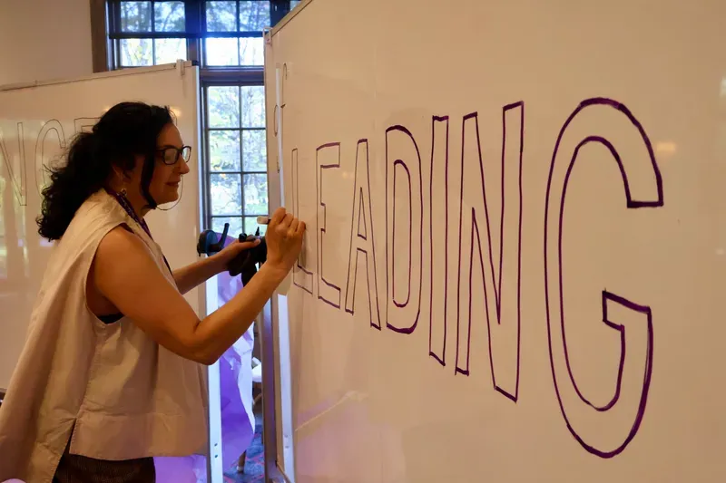 Saffron Samuels hand-lettering LEADING on a whiteboard
