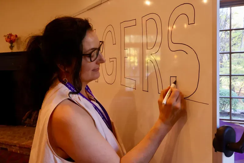 Saffron Samuels hand-lettering a program whiteboard