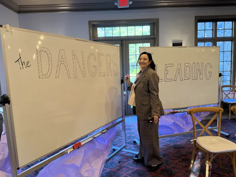 Saffron Samuels beside the lettered program boards